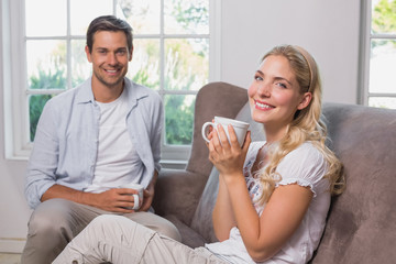 Obraz na płótnie Canvas Portrait of relaxed couple with coffee cups in living room