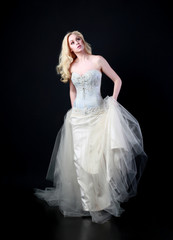 Fototapeta premium pełnej długości portret kobiety na sobie białą suknię ślubną. stojąca trucizna czarne studio tło.