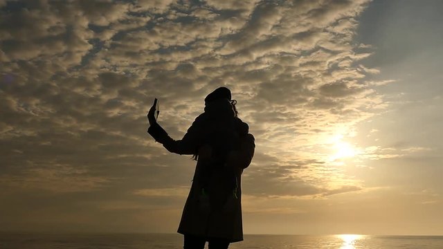 Selfie making and rotation of mother and son on sky background panoramic slow motion