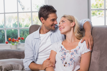 Relaxed loving young couple sitting on sofa