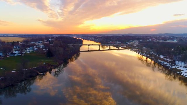 Amazing time lapse view of colorful sunrise sky reflected in mirror smooth river.
