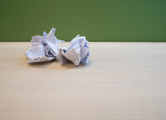 Crumpled paper was left on a wooden desk