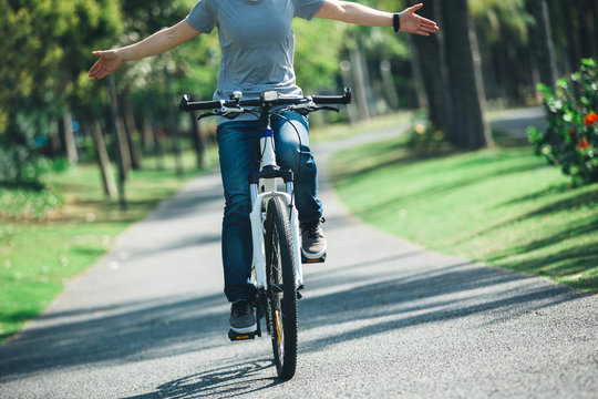woman cyclist riding bike on tropical park