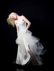 Naklejka premium full length portrait of woman wearing white bridal gown. standing poison black studio background.
