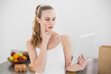 Thoughtful young woman using her digital tablet 