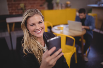 Portrait of smiling young attractive woman using mobile phone