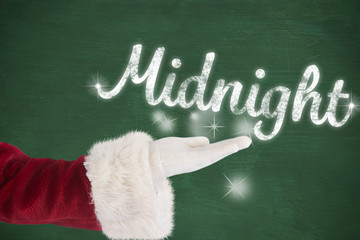 Santa Claus shows open hand against green chalkboard