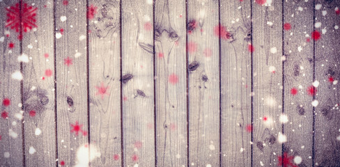 Snowflakes against close-up of wooden fence