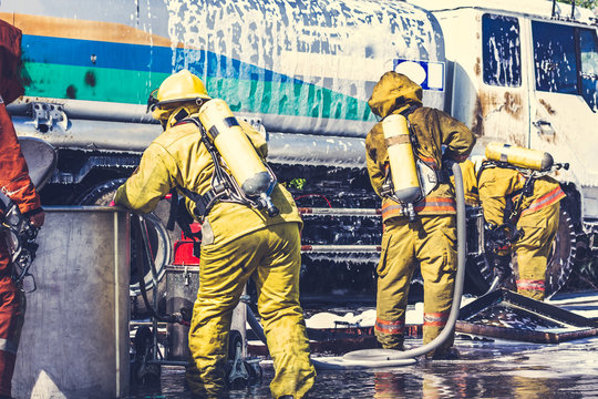 Firemen in firefighter uniform are checking their equipment after use.