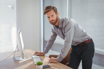 Portrait of confident executive working on personal computer at desk