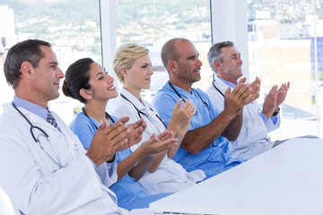 Team of doctors applauding during meeting