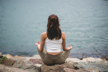 Fototapeta na wymiar Woman Meditating by Sea