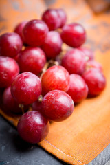 Sweet bunch of red grapes on th rustic background. Selective focus. Shallow depth of field.