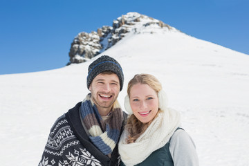 Fototapeta na wymiar Couple in front of snowed hill and clear blue sky