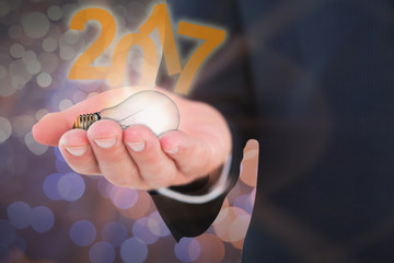 Mid section of a businessman with hands out against glowing background
