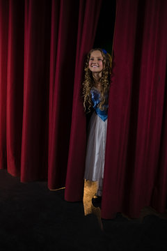 Female Artist Peeking Through The Red Curtain