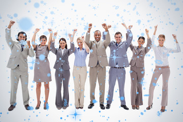 Happy business team raising their arms against snow falling