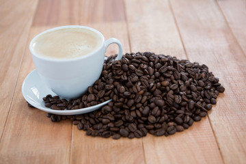 Cup of coffee with roasted coffee beans