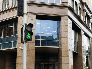 green pedestrian traffic sign on the traffic light.