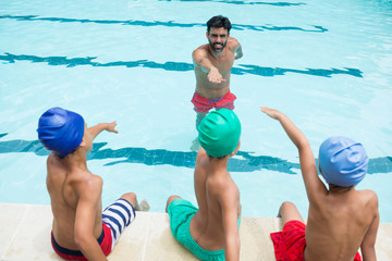 Coach and students taking oath in swimming pool