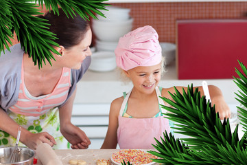 Cheerful mother and her daughter baking in a kitchen against digitally generated fir tree branches