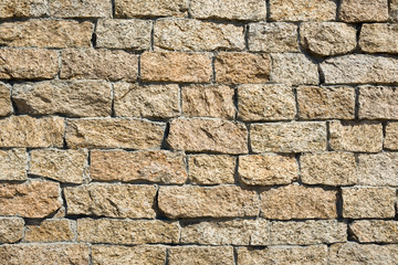 Wall made of crushed stone in the sunlight 