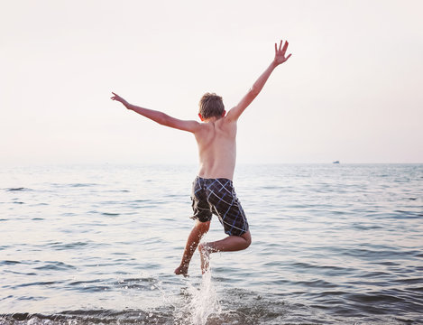 Boy jumping  into the lake.