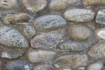 Wall of round granite stones, texture, background