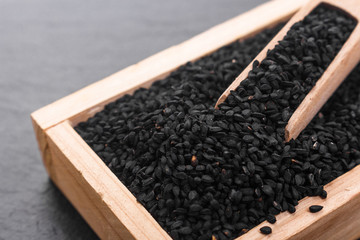 grains of black cumin and oil on the rustic background