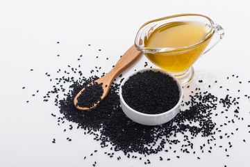 grains of black cumin and oil on the rustic background