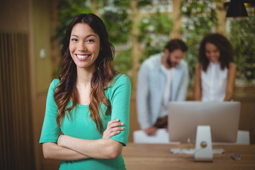 Female executive standing with arms crossed