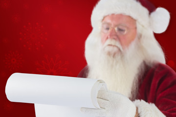 Naklejka premium Santa Claus reads a list against red background