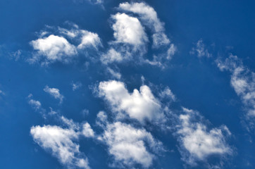 White fluffy clouds in the vast blue sky. Abstract nature background.