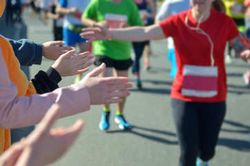 Marathon running race, support runners on road, child's hand giving highfive, sport concept
