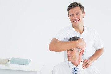 Male chiropractor doing neck adjustment