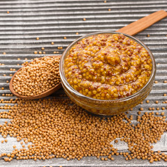 mustard in a bowl on a rustic background