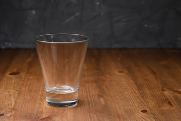 empty glass glass stands on a wooden table.
