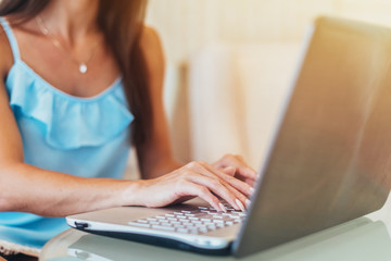 Close-up shot of female hands typing on laptop keyboard