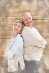 Mature couple standing and smiling at camera against light glowing dots design pattern