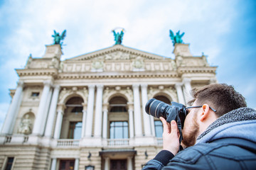 tourist man taking picture of old european architecture. copy space. travel concept