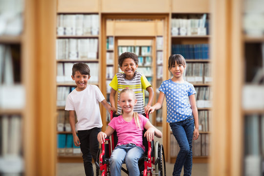 Cute disabled pupil smiling at camera with her friends against library