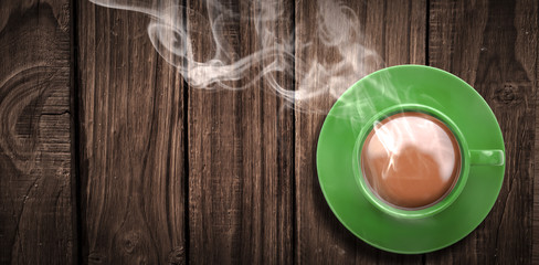Overhead view of green tea cup against wooden table