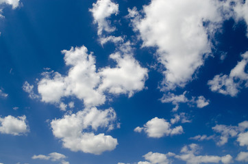 Naklejka na ściany i meble Blue sky with white clouds in sun rays