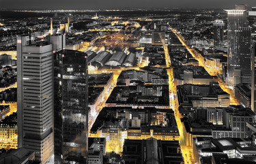 High quality black and white aerial panoramic view of Frankfurt, Germany at dusk. Yellow street traffic lights between the buildings.