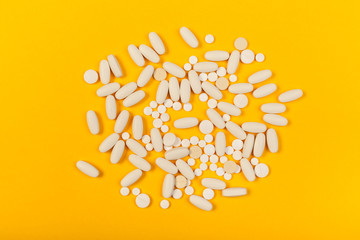 White medical pills on color background