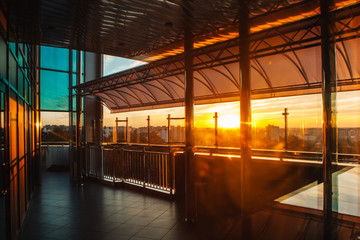 corridor on the top floor of a skyscraper at sunset overlooking a part of the city