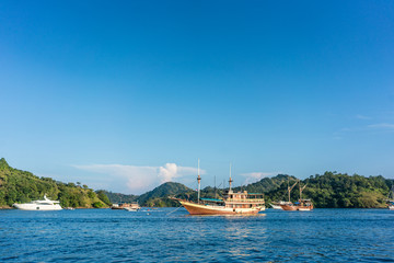 Idyllic seascape with sailing boats moored along the shore in a sunny day of summer in Flores Island, Indonesia