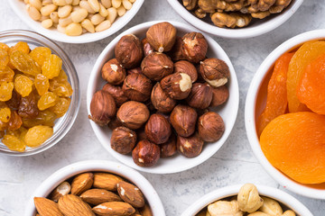 Nuts and dried fruits assortment on stone table top view.