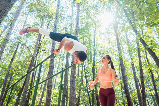 Sportive couple, woman and man, doing workout in outdoor gym