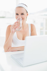 Content pretty sportswoman drinking water